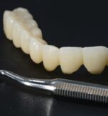 Punte din zirconiu și instrument de finisare pe masa laboratorului dentar
