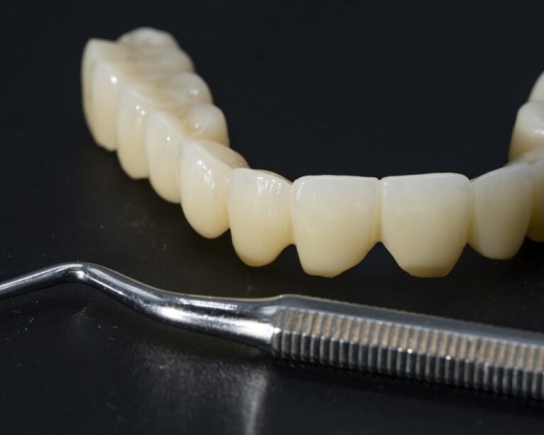 Punte din zirconiu și instrument de finisare pe masa laboratorului dentar