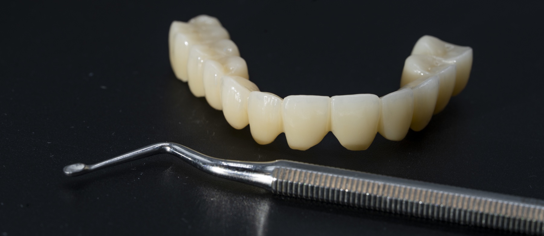 Punte din zirconiu și instrument de finisare pe masa laboratorului dentar